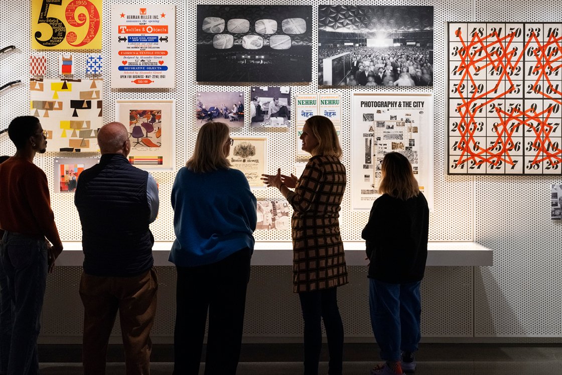 Several guests being led on a tour of the gallery by Llisa Demetrios, chief curator of the Eames Institute.